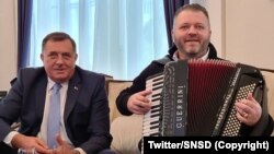 Anëtari i Presidencës së Bosnjës dhe Hercegovinës Millorad Dodik së bashku me një muzikant në zyrën e tij.