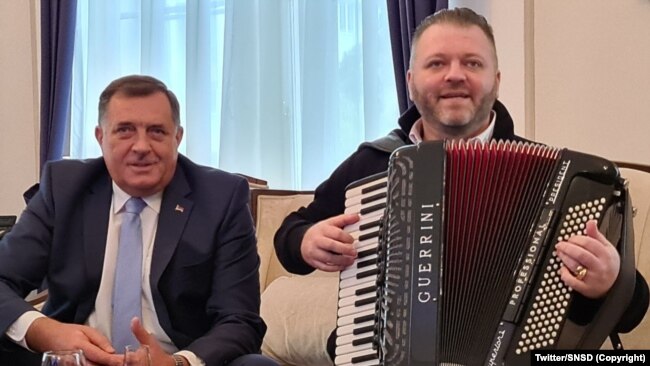 Anëtari i Presidencës së Bosnjës dhe Hercegovinës Millorad Dodik së bashku me një muzikant në zyrën e tij.