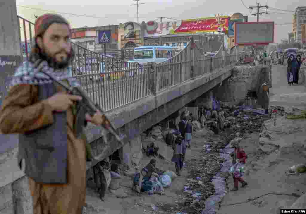 A member of the Taliban stands guard next to a bridge that is a popular gathering spot for drug users in Kabul on October 9.