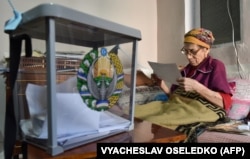 An elderly woman casts her ballot at home in Tashkent on October 24.