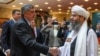 Russian envoy to Afghanistan Zamir Kabulov (left) shakes hands with a member of the Taliban delegation before talks in Moscow in October 2021. With the new deal, Moscow joins a short list of capitals willing to deal with the Taliban.