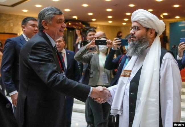 Russia's presidential envoy to Afghanistan, Zamir Kabulov (left), shakes hands with Mawlawi Shahabuddin Dilawar, a representative of the Taliban delegation, before the beginning of international talks on Afghanistan in Moscow in October.
