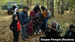 A group of Iraqi migrants is surrounded by border guards and police in Hajnowka after they crossed the Belarusian-Polish border on October 14.