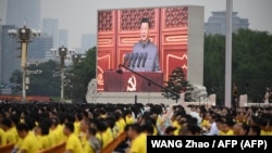 Председатель КНР Си Цзиньпин (на экране) произносит речь на праздновании 100-летия основания Коммунистической партии Китая на площади Тяньаньмэнь в Пекине, 1 июля 2021 года
