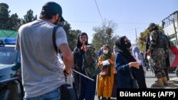 თალიბანის მებრძოლი ცდილობს შეაჩეროს ჟურნალისტი, რომელიც ქალთა უფლებების დამცველთა საპროტესტო აქციას აშუქებს ქაბულში. 2021 წლის 21 ოქტომბერი