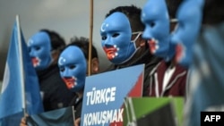 Demonstranti u Turskoj sa maskama u bojama zastave kineske pokrajine Sinđijang, koju Ujguri nazivaju Istočni Turkistan. Procenjuje se da je u Turskoj oko 50 hiljada ujgurskih izbeglica, koji su pobegli od represije kineskih vlasti. 
