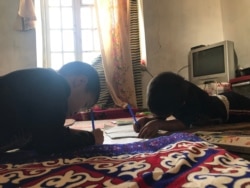 Дети жительницы села Достык Сарагуль Искуловой делают уроки в единственной жилой комнате. Туркестанская область, 5 октября 2021 года.