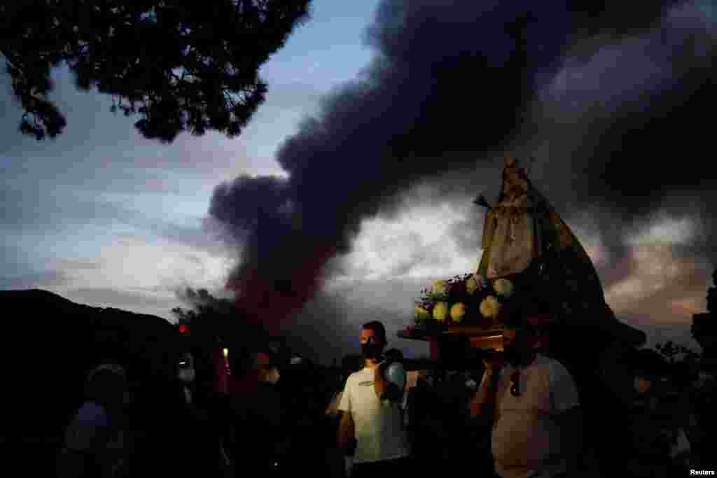 Процесія з Вірген-дель-Піно (Сосновою Дівою) в Ель-Пасо. Люди моляться за зупинення виверження вулкану Кумбре-В&#39;єха на Канарському острові Ла-Пальма, Іспанія, 19 жовтня 2021 року