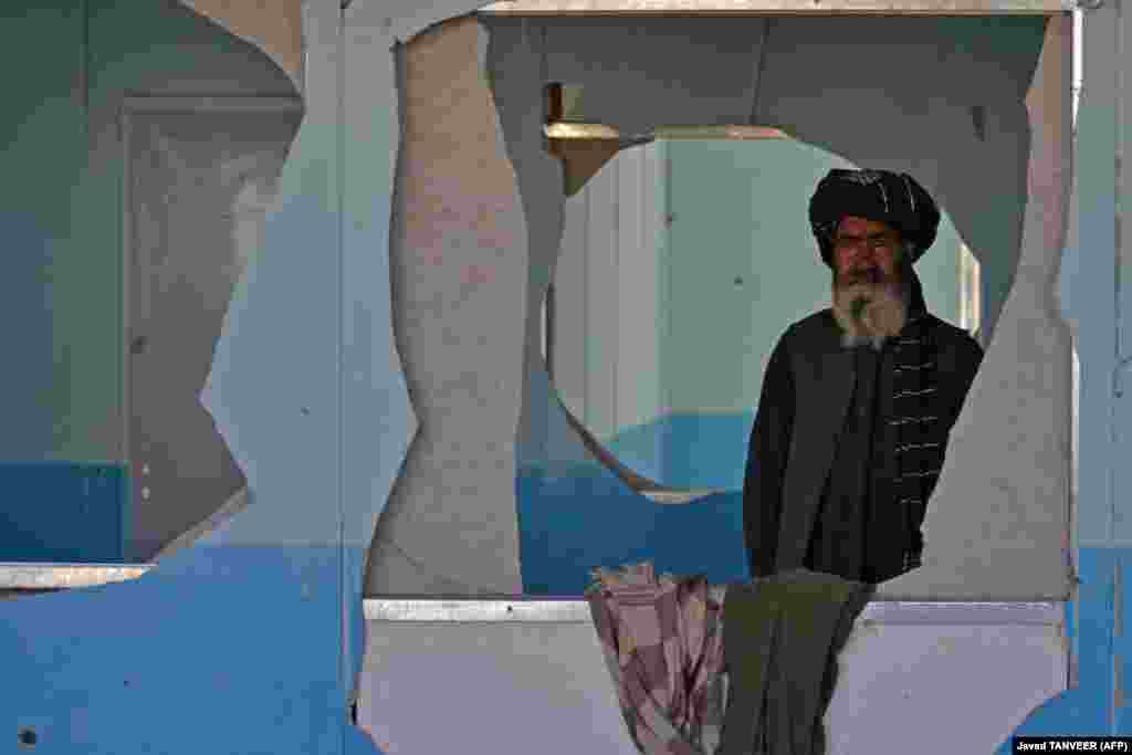 Настаўнік стаіць у абстралянай кулямі школе ў вёсцы Бабро ў афганскім раёне Аргандаб