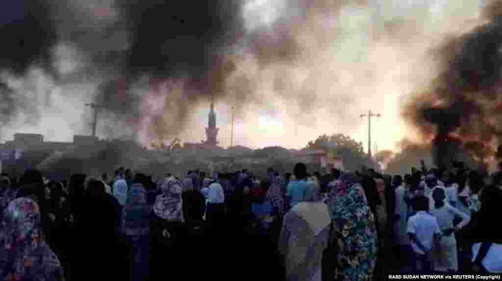 Sudan - People gather on the streets as smoke rises in Kartoum, Sudan, amid reports of a coup, October 25, 2021, in this still image from video obtained via social media. R