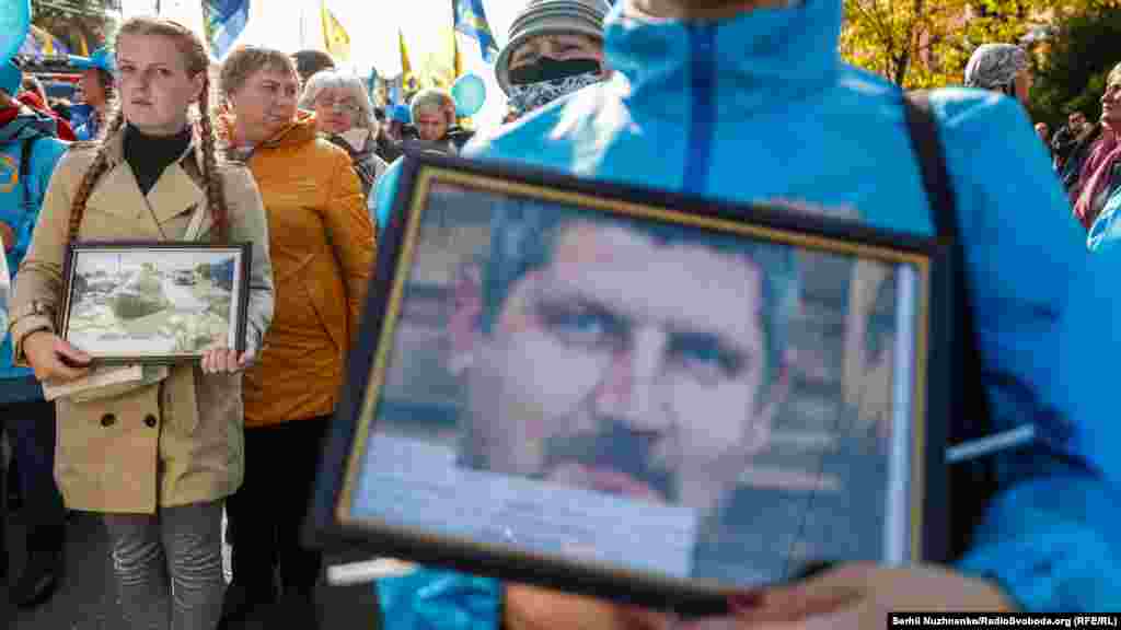 Participants hold photos of relatives who have died in the conflict with separatist forces in eastern Ukraine.&nbsp;