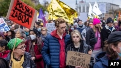 People in Warsaw take part in a protest rally on October 17 in solidarity with migrants who have been pushed back at Poland's border with Belarus.