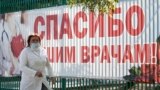 Медицинский работник на фоне баннера «Спасибо нашим врачам». Судак, Крым, 21 октября 2021 года. Иллюстрационное фото