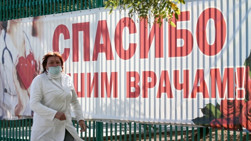 Медработник на фоне банера «Спасибо нашим врачам» в Судаке | Крымское фото дня