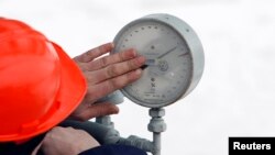 Një punëtor duke inspektuar një matës të presionit të gazit në Rusi. Janar, 2022.