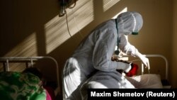 Медицински работник се грижи за пациент в отделение за лечение на коронавирус в Русия