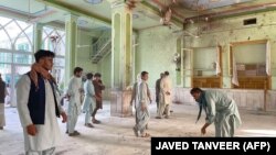 Afghan men inspect the damage inside a Shi'ite mosque in Kandahar on October 15 after a suicide bomb attack during Friday Prayers.
