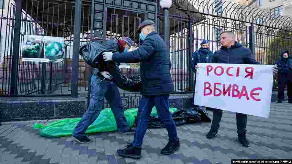 Учасники акції виклали перед парканом російського посольства у Києві загорнуті у поліетилен символічні &laquo;тіла померлих&raquo;