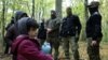 An Iraqi migrant child stands as he and others are surrounded by border guards and police officers after they crossed into Poland from Belarus. 