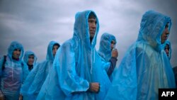 Migranți și refugiați, așteptând să se înregistreze într-o tabără din Macedonia, după ce au trecut frontiera greacă, 22 septembrie 2015