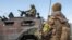 Украинские солдаты осматривают российскую военную технику, Харьков, февраль 2022 года 