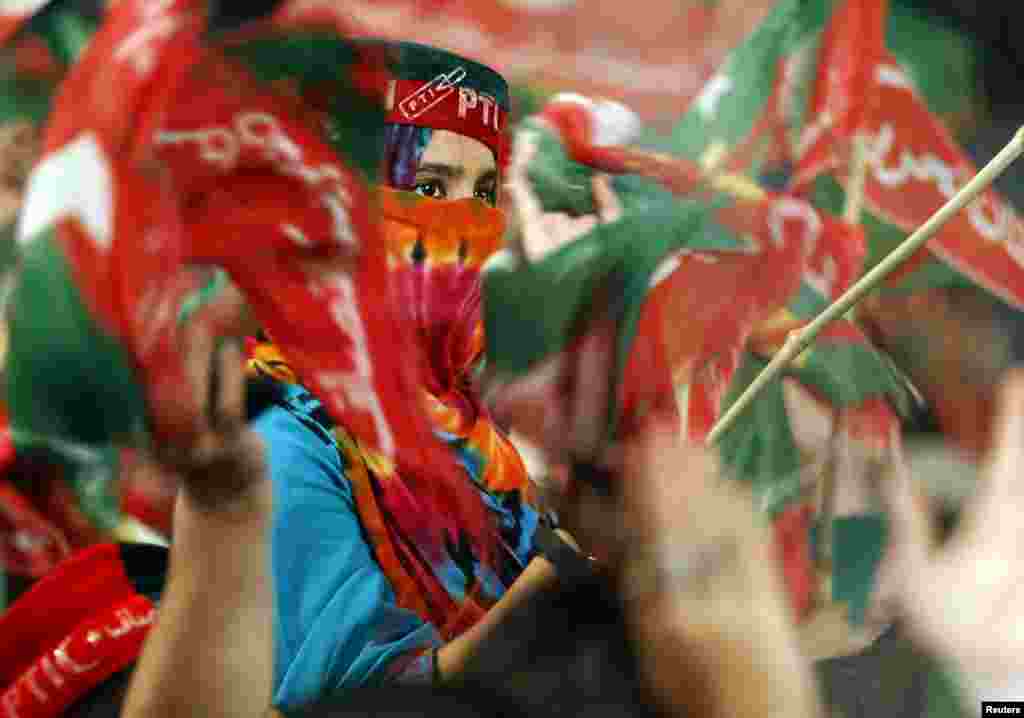 People cheer and wave flags as Pakistani opposition politician Imran Khan arrives at a rally in Islamabad. (Reuters/Caren Firouz)