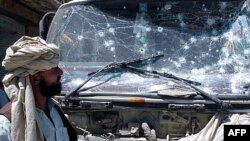 FILE: An Afghan man looks at a vehicle damaged by a suicide attack in Gardez.