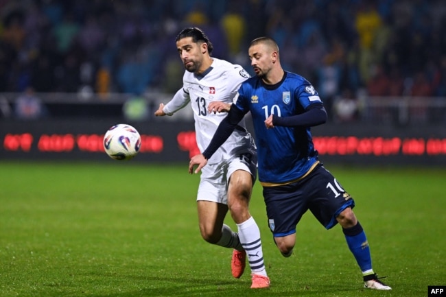 Mbrojtësi i Zvicrës, Ricardo Rodriguez (majtas), lufton për topin me sulmuesin e Kosovës, Edon Zhegrova, gjatë ndeshjes kualifikuese të Grupit B për Kupën e Botës 2026 midis Kosovës dhe Zvicrës, në Prishtinë.