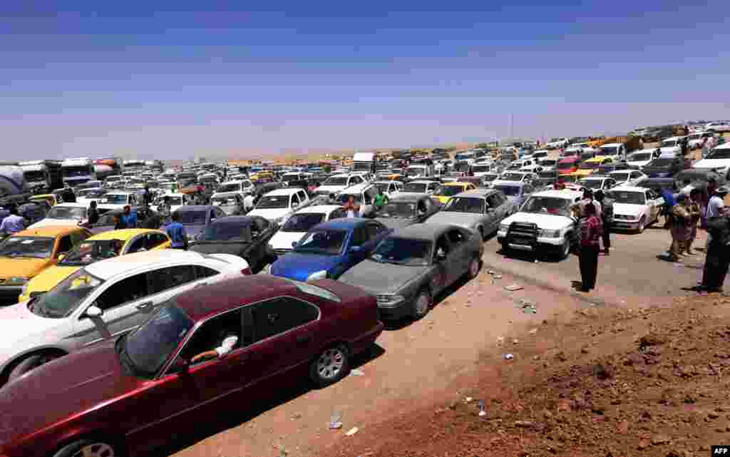 Iraqis fleeing violence in Nineveh Province wait in their vehicles at a Kurdish checkpoint in Aski Kalak, 40 kilometers west of Irbil, the capital of the northern autonomous Kurdish region, on June 10. (AFP/Safin Hamed)