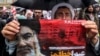 A Shi'ite Muslim cleric holds a poster reading "crossing a red line" in Persian next to an image of Hassan Nasrallah during an anti-Israel protest in Tehran's Palestine Square on September 28.