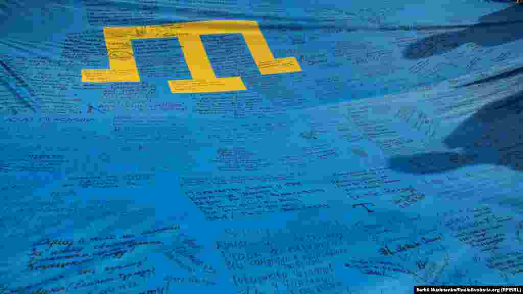 2019 senesi iyün ayı. Kyivde Qırımtatar bayraq künü. 3-ke 4,5 metr büyüklikte bayraq dünyanıñ 28 memleketinden keçti, onı qırımtatar ve Ukrayına diasporalarınıñ vekilleri, siyasetçi ve faaller imzaladı