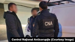 Imagine distribuită de CNA de la reținerea directoarei Liceului „Gheorghe Asachi” din Chișinău și reprezentantul unui agent economic, 30 octombrie.