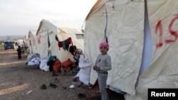 Дете стои надвор од шатори подигнати за луѓето погодени од разурнувачки земјотрес, во градот Јандарис, контролиран од бунтовниците, Сирија, 11 февруари 2023 година. 