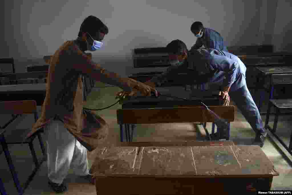 A worker sprays disinfectant in a classroom at a private school in Karachi, Pakistan, on September 14 following a government announcement that educational institutions would be reopening nearly six months after the start of the COVID-19 pandemic.