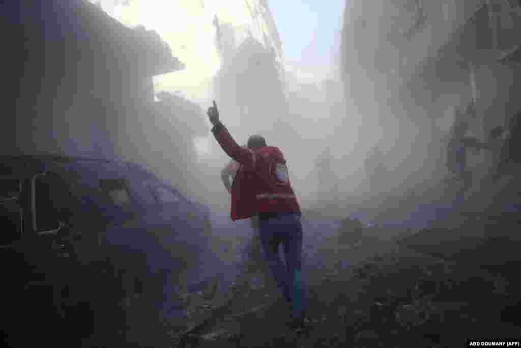 &nbsp;A member of the Syrian Arab Red Crescent runs as he searches for victims following a reported government air strike on the rebel-held town of Douma near Damascus. (AFP/Abd Doumany)