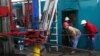 Floor hands and engineers adjust a down-hole motor used for directional drilling on a gas-drilling platform in the Barnett Shale near Fort Worth, Texas.