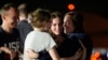 RFE/RL journalist Alsu Kurmasheva (right) hugs her daughters, Bibi and Miriam, as her husband, Pavel Butorin, looks on at Andrews Air Force Base following her release as part of a 24-person prisoner swap between Russia and the United States late on August 1.