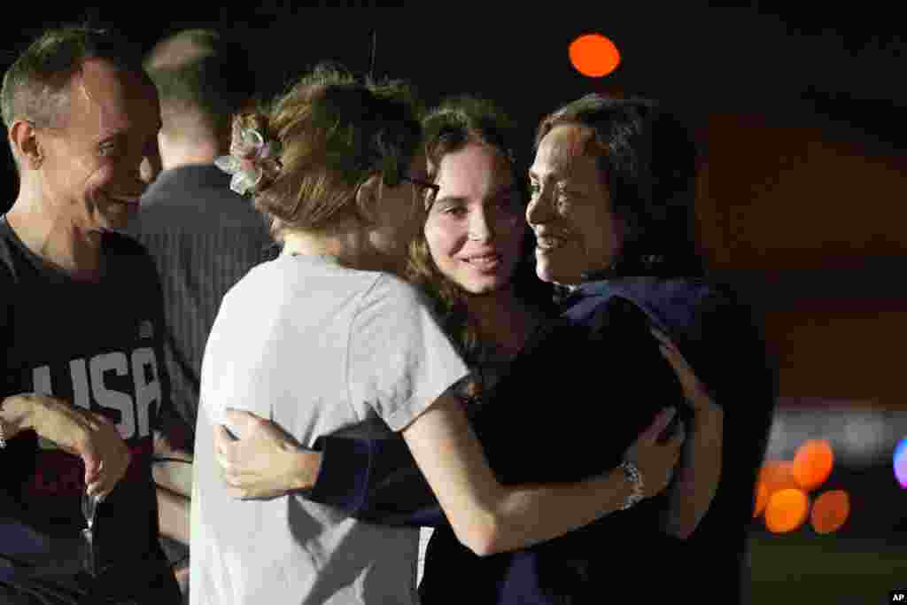 RFE/RL journalist Alsu Kurmasheva (right) hugs her daughters, Bibi and Miriam, as her husband, Pavel Butorin, looks on at Andrews Air Force Base following her release as part of a 24-person prisoner swap between Russia and the United States late on August 1.