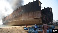 A Pakistani man looks at the wreckage of a burning ship a day after a gas cylinder explosion at the Gadani ship-breaking yard, some 50 kilometers west of Karachi, on November 1. 