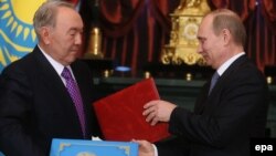 Президент Казахстана Нурсултан Назарбаев и президент России Владимир Путин обмениваются документами. Москва, 24 декабря 2013 года.