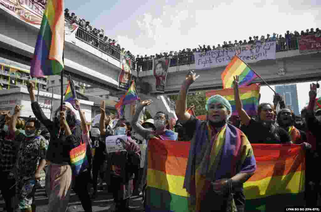 Membrii comunității lesbiene, gay, bisexuale, transgender și queer (LGBTQ) flutură steaguri în timp ce participă la un protest împotriva loviturii de stat militare, în Yangon, Myanmar, 8 februarie 2021.
