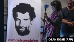 Osman Kavala posztere ügyvédjei sajtótájékoztatóján 2018. október 31-én.