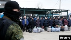 Боевик «ДНР» и украинские заложники во время обмена пленными у КПВВ «Майорское» 29 декабря 2019 года