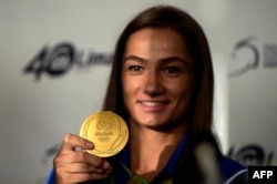 Kosovar judoka Majlinda Kelmendi shows her gold medal to fans during a welcoming ceremony in Pristina in August 2016.