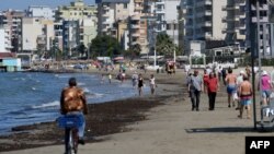 Луѓе шетаат на плажа во Драч на 10 јуни 2020