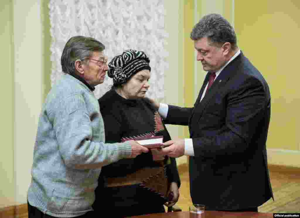 Прэзыдэнт Украіны Пятро Парашэнка вручае бацькам Міхала ордэн Нябеснай Сотні.