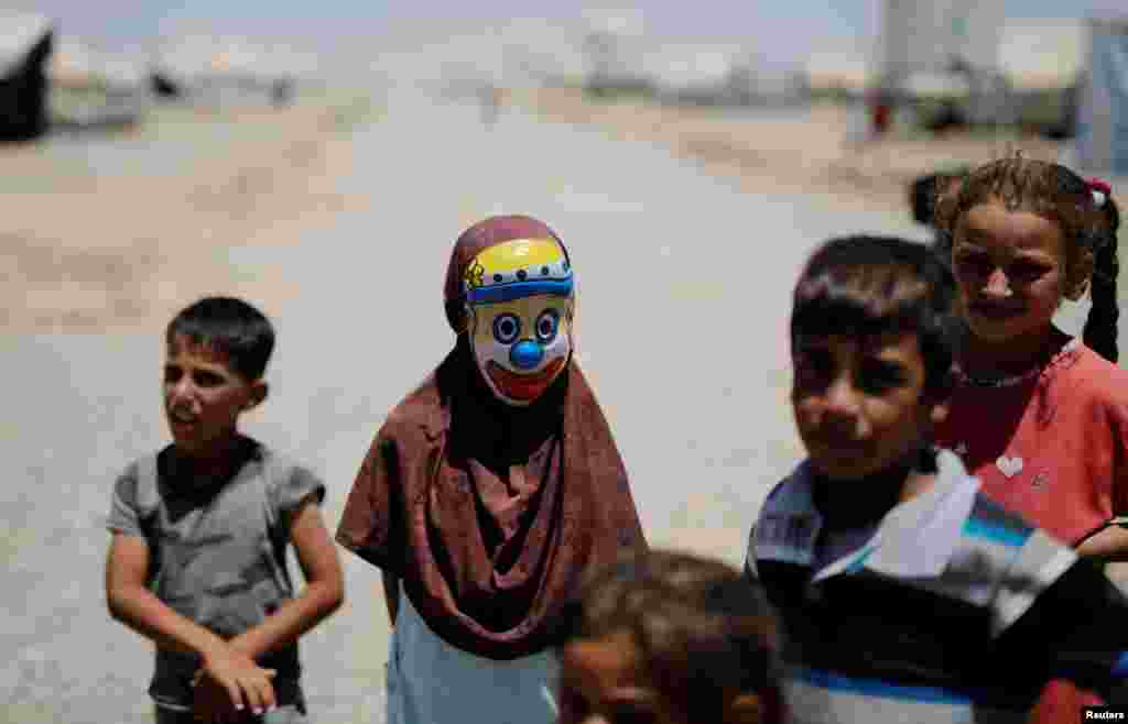 A displaced Iraqi girl wears a clown mask at the Hasansham camp in Al-Khazer, east of Mosul. (Reuters/Alkis Konstantinidis)