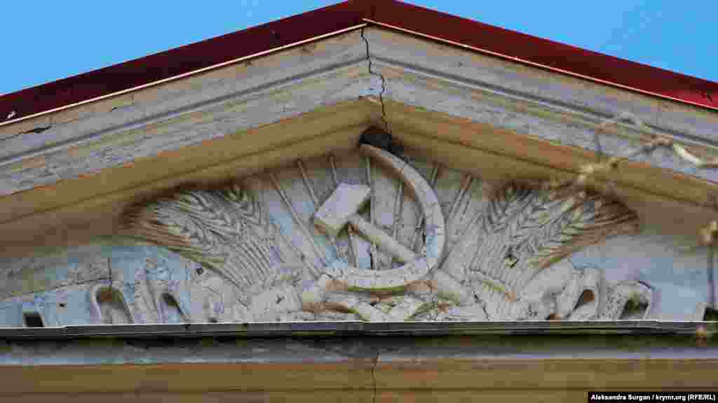 Барельеф серпа и молота под крышей здания суда
