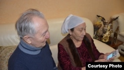 Кудайберген Айтбаев и Миуа Низамудинова смотрят в телефоне сообщение о выступлении их внука Димаша Кудайбергена в Китае.