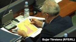 Një deputet i Kuvendit të Kosovës, duke shikuar një hartë për demarkimin e kufirit me Malin e Zi